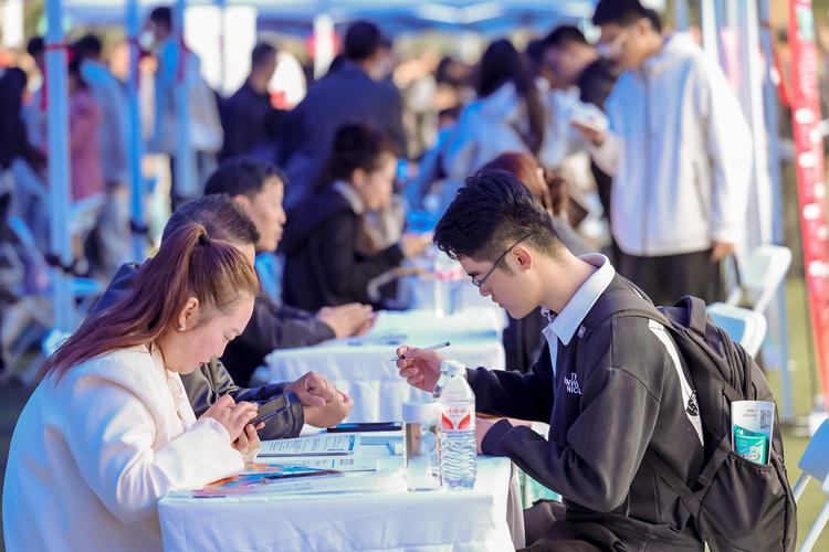 2024年高校秋季双选会现场学生排队投简历场景