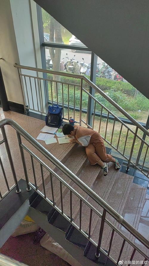 城中村单元楼消防台阶上写作业的小学生