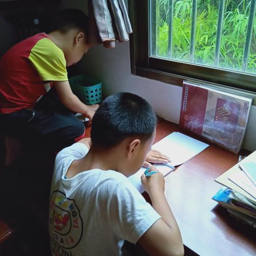 工业园职工宿舍姐弟俩一起写作业实景照