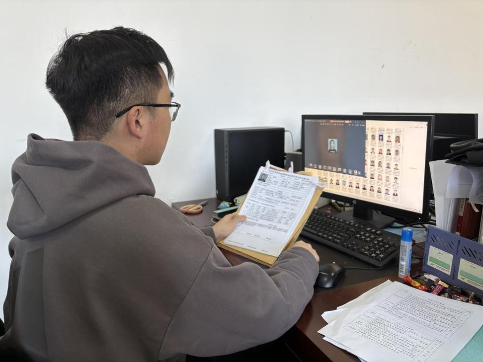 老师正在电脑前核对学生学籍信息