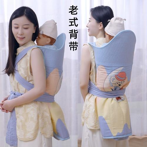年轻妈妈学用传统长背巾把婴儿绑在身后