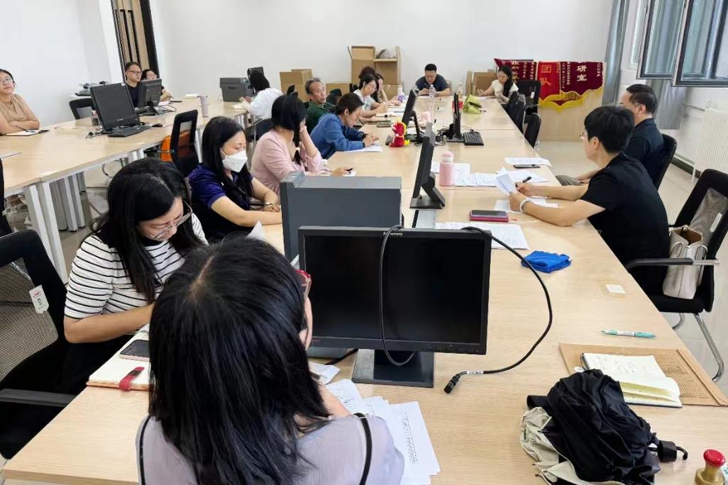 教师办公桌面堆满培训资料笔记本场景