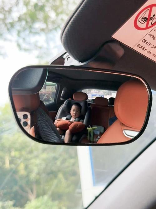 妈妈开车时从后视镜看后座孩子互动场景