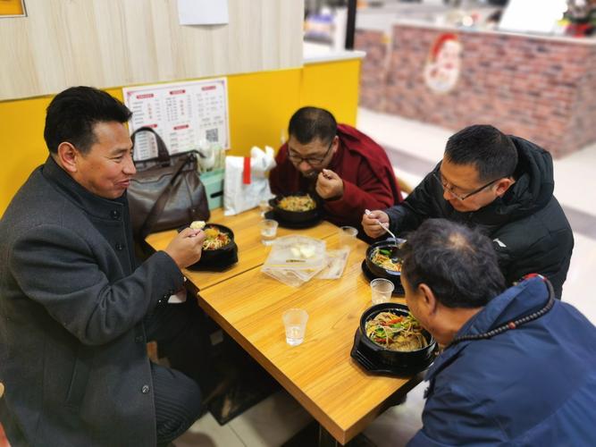 管理者和老员工在社区小吃店面对面聊天的场景