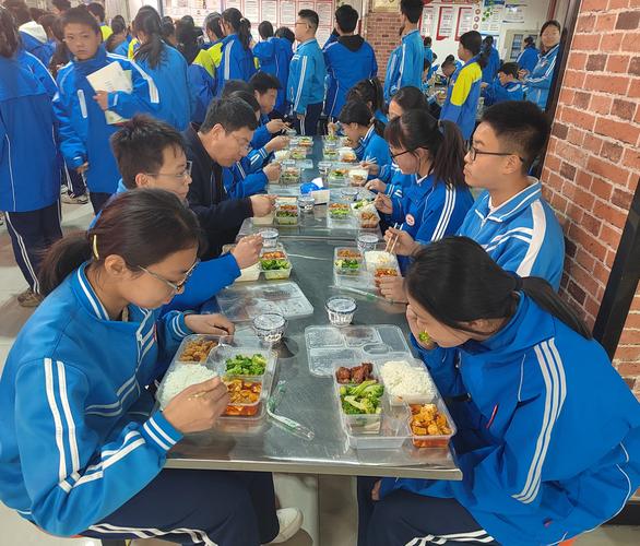 校长在学校食堂和学生一起打饭场景
