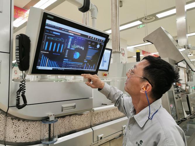 年轻工业人给退休父亲展示智能工厂操作面板