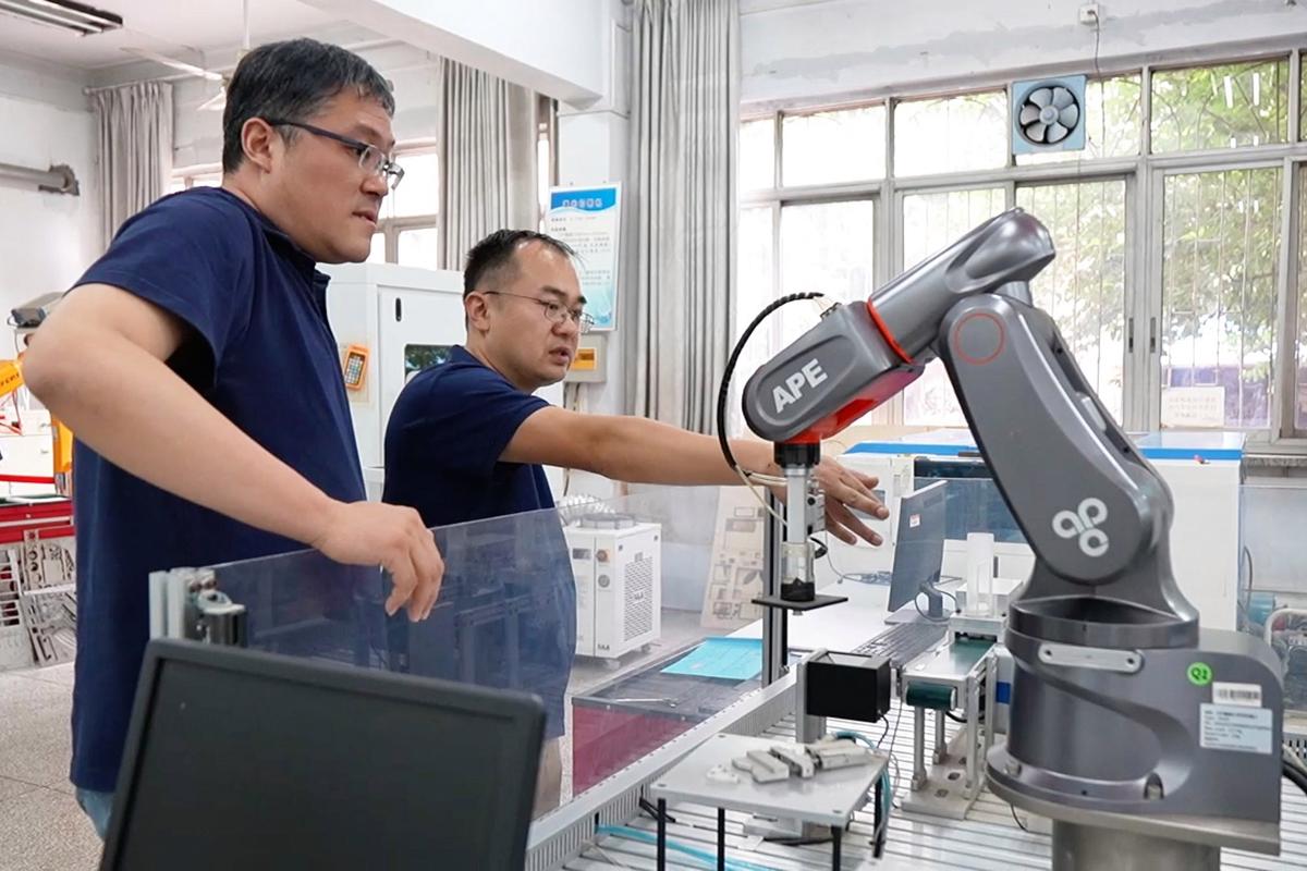 高校教授在企业车间调试设备 产学研合作