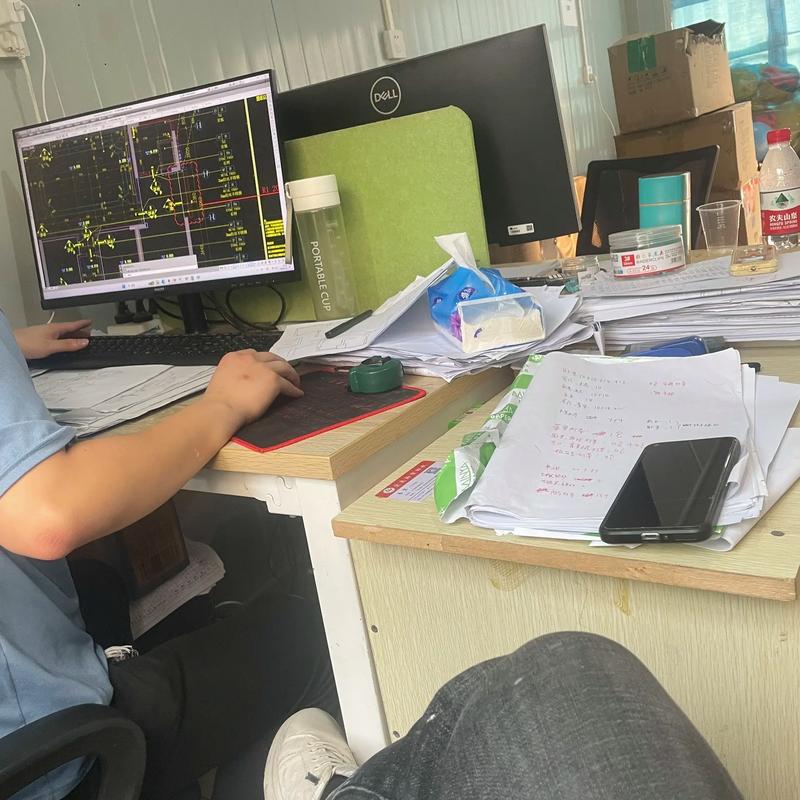 造价工程师深夜在办公室核对工程图纸