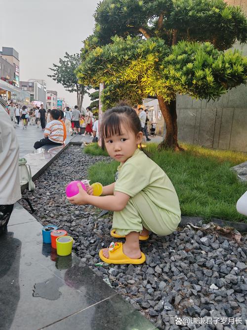 小学门口花坛边蹲着想事情的小女孩