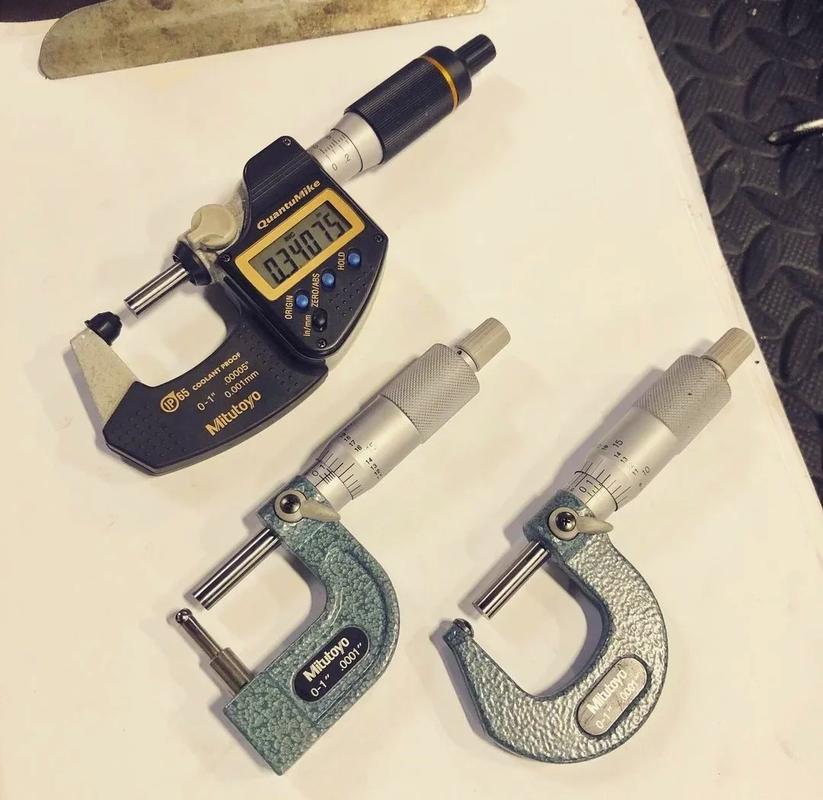 机加工检验员用千分尺测量加工中轴类零件