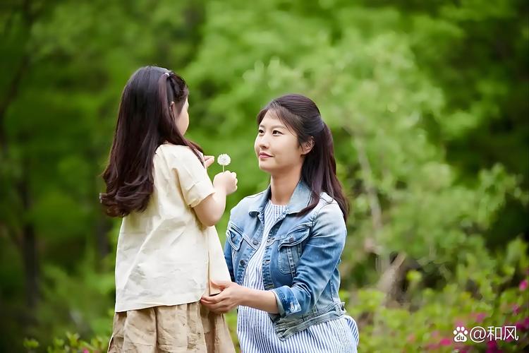妈妈和孩子一起蹲着看草地野花特写