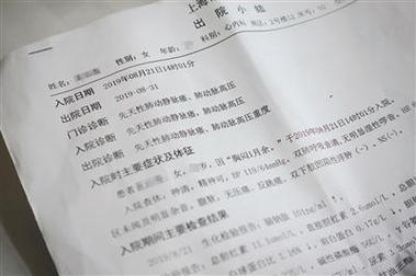 患者坐在病床上核对出院小结内容实拍