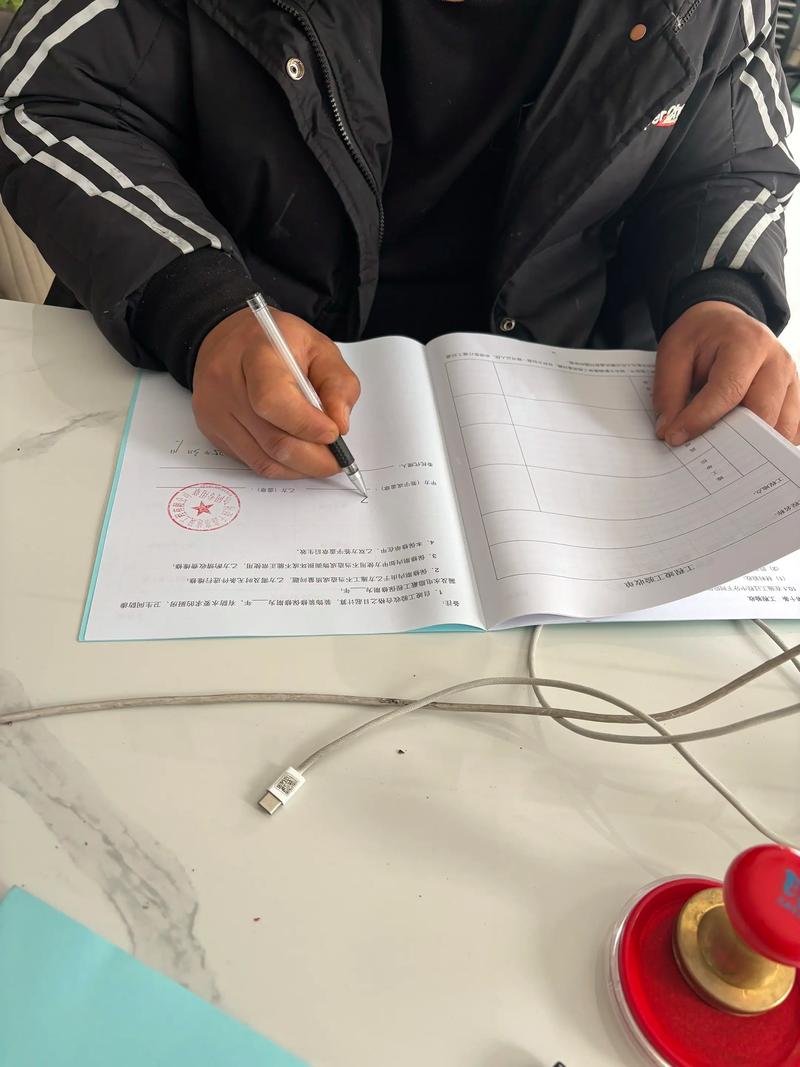 劳动合同签约特写镜头,桌面摆着签字笔和工牌