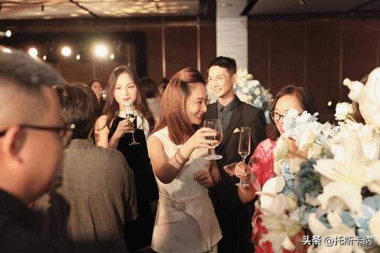 婚礼晚宴暖黄灯光下围坐交谈的宾客细节