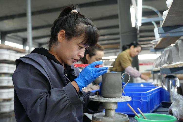 陶瓷工厂车间工人戴劳保手套用手持终端扫码核对生产工单