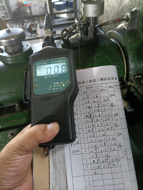 机械车间老师傅手持巡检仪记录机床主轴振动值