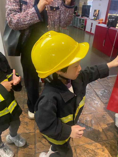 孩子佩戴安全帽在车间参加家族聚会安全游戏