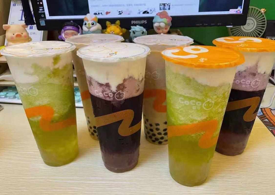 各种奶茶品牌杯子堆满桌面的实拍图