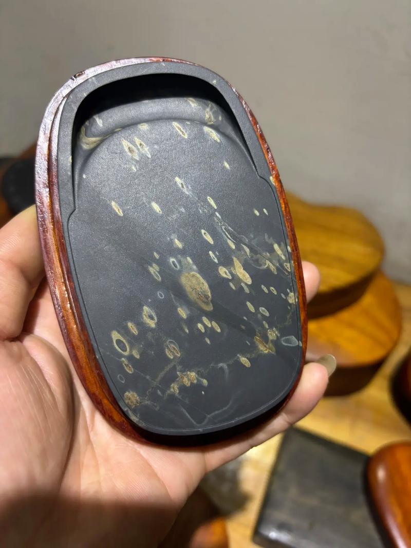 歙砚金星金晕纹理在灯光下的反光特写