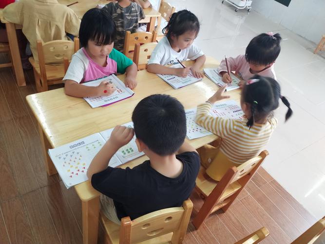 幼儿园孩子集体做纸质数学练习题场景