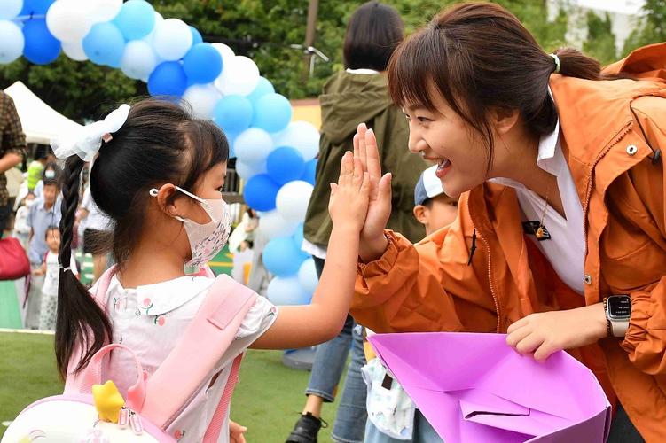 幼儿园教室门口家长与孩子击掌告别的温馨画面
