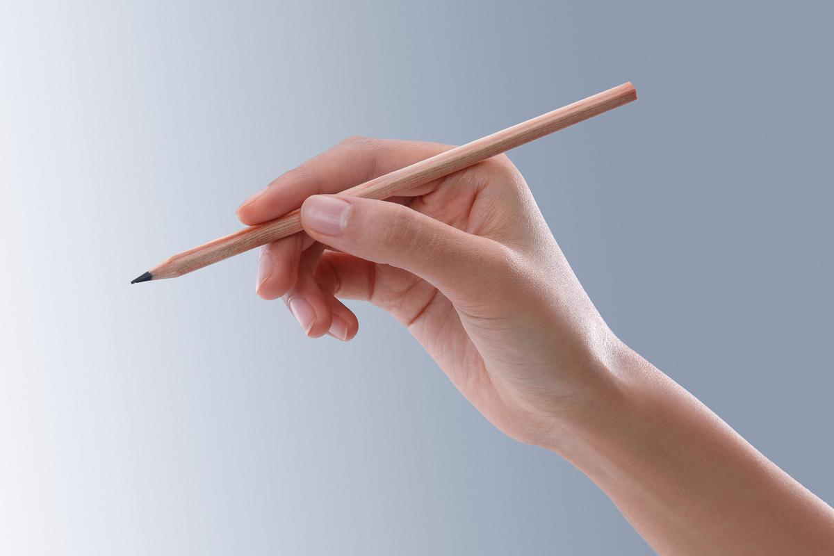 学生握笔抠指尖的手部特写