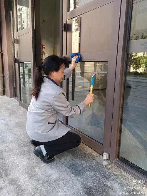 小区保洁员擦拭单元门扶手现场