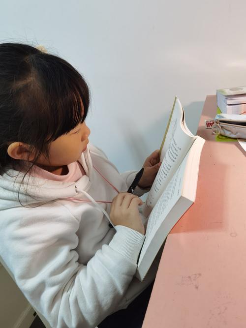 小学三年级孩子对着语文书皱眉头的居家学习真实场景