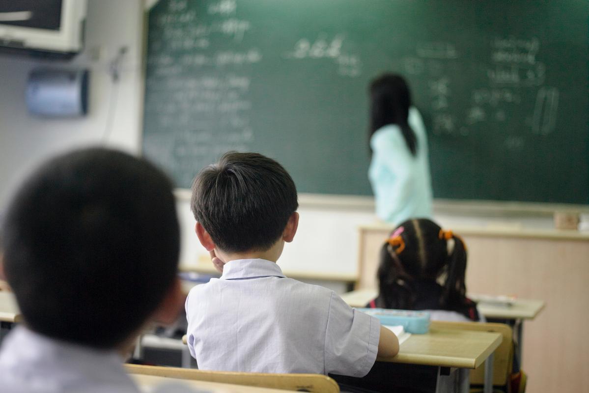 中小学教室后排站立反思的学生背影