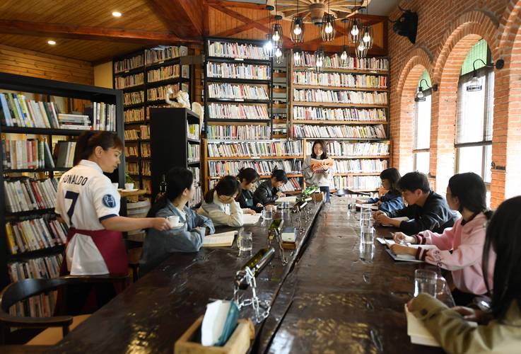 年轻人咖啡馆整理求职简历场景图