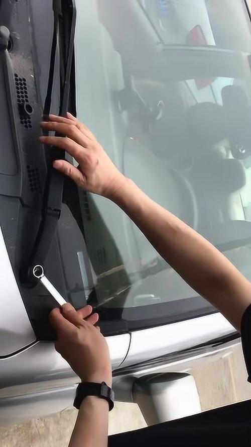 汽修师傅用活动扳手调整汽车雨刮臂安装角度的现场实拍