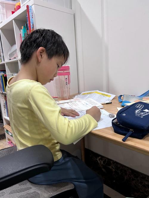 小学教室后排独自写作业的小学生