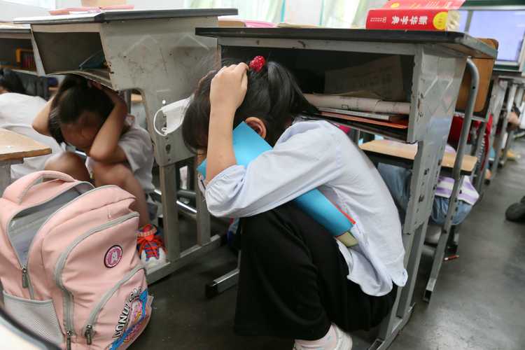 初中课堂上学生把手藏在桌下躲避老师提问的实拍