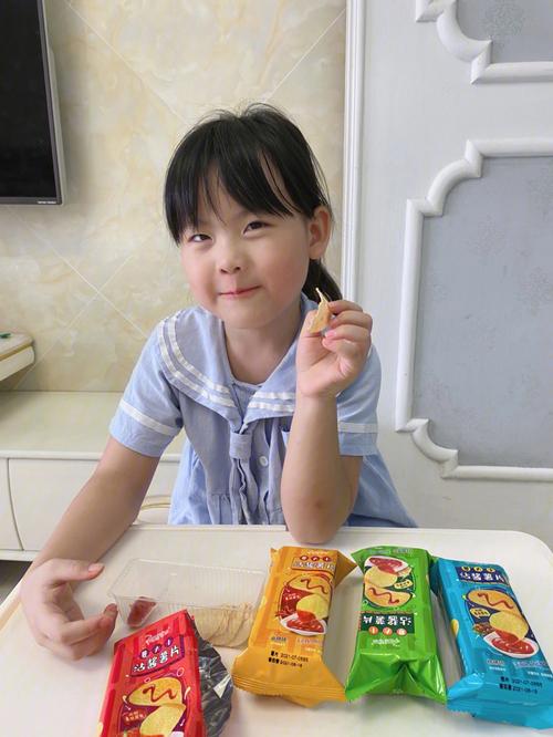 家庭餐桌上小女孩分零食的随手拍
