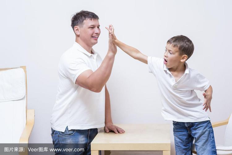 父亲和儿子在客厅击掌约定承诺