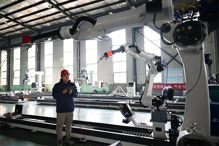 工人手持示教器调试工业机器人焊枪角度