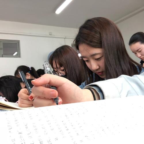 教师在楼梯间看着学生周记本红了眼的手部特写