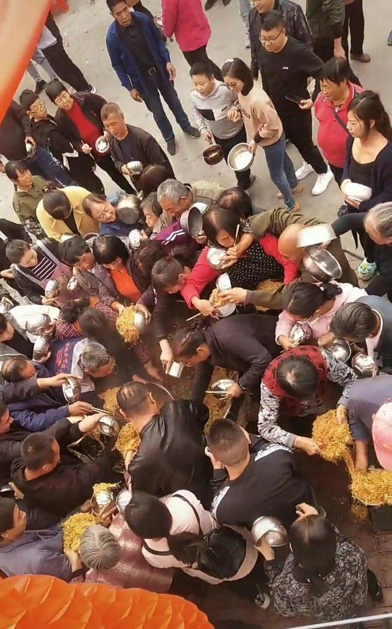 青阳乔迁喜宴上蹲在门槛吃炒米面的人群场景