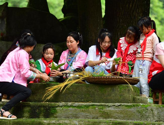 苗族儿童在寨子里学习使用生活工具