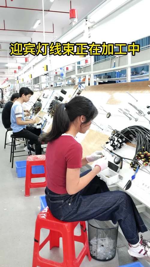 工业设计师在车间手持样品与装配线工人交流细节
