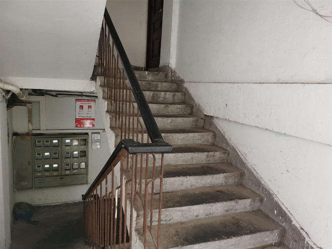 小学生在老小区楼道记录公共设施损坏情况