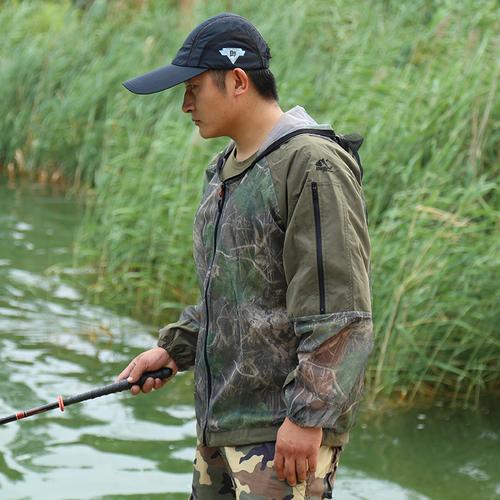 钓鱼人身穿防晒衣戴宽檐帽在河边垂钓