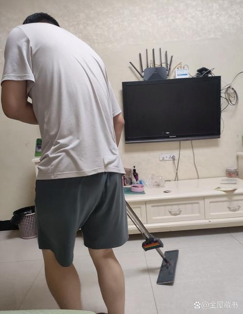 父亲蹲下和孩子一起擦地板的背影