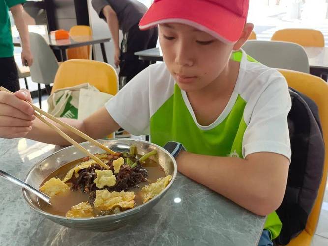 高速服务区蹲坐吃泡面的研学儿童