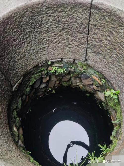 青苔斑驳的古井细节特写,井圈上深深的绳痕