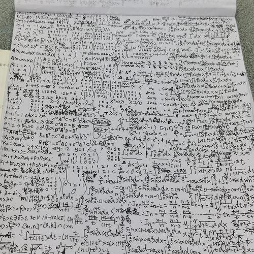 小学男生在客厅地板上摊草稿纸算数学题