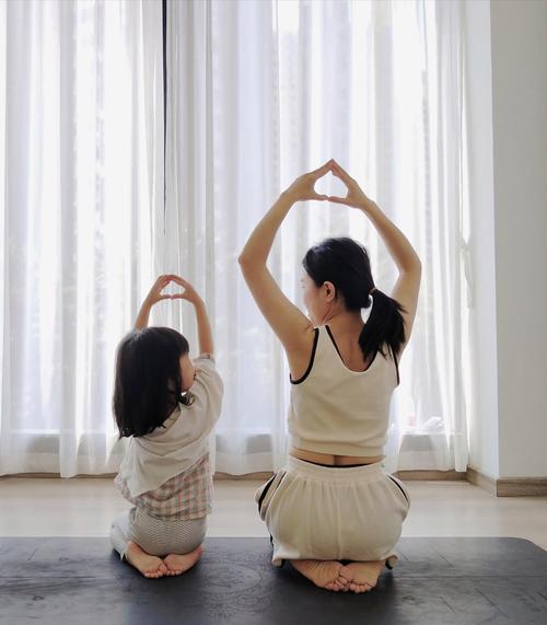 妈妈陪孩子在家客厅做儿童冥想互动图