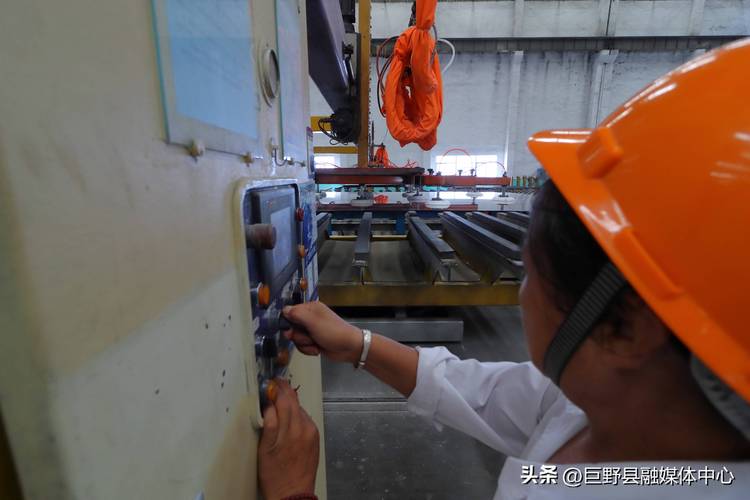 五金厂行车操作室师傅隔着玻璃向外张望的实拍图