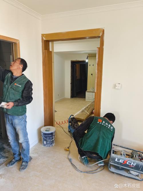 装修工人用热风枪去除旧木门油漆现场