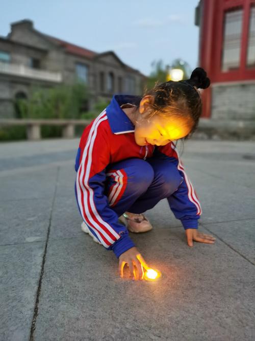 小朋友蹲在地板上盯着亮起来的发光二极管的惊喜侧脸